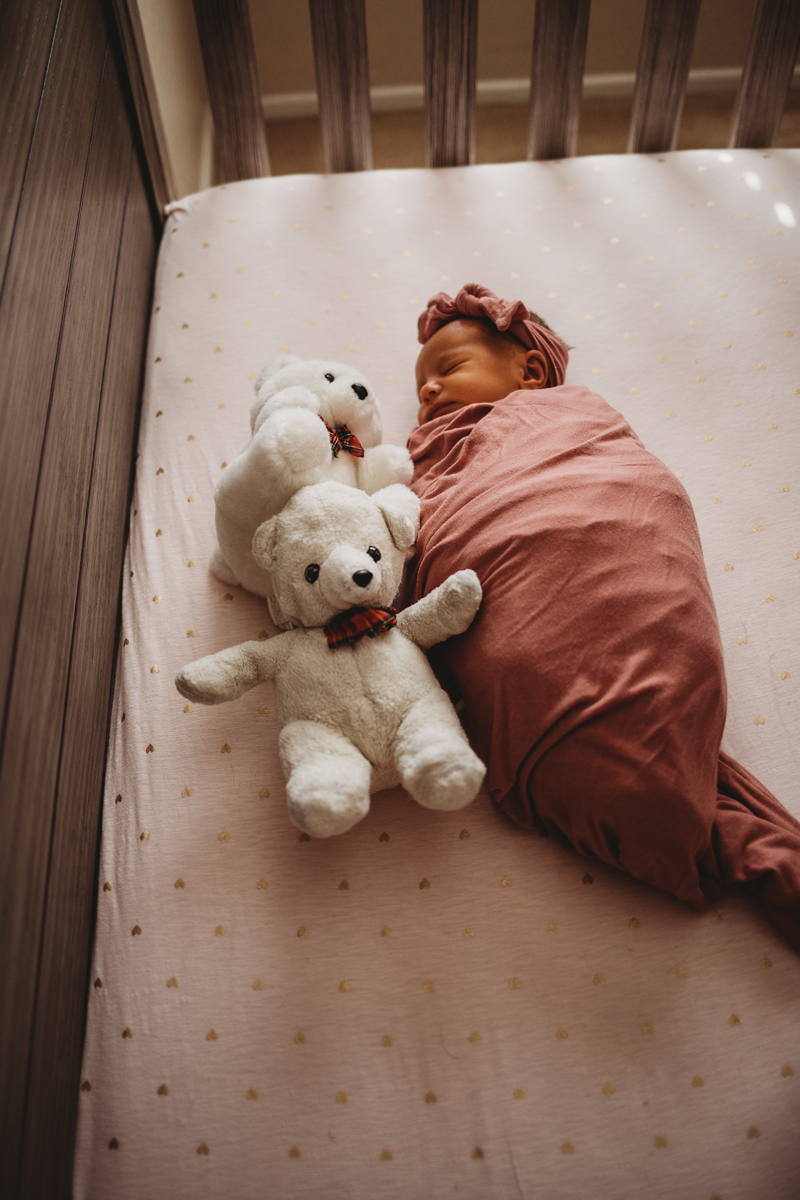 Temecula Newborn Photographer, swaddled baby girl in crib next to stuffed bears