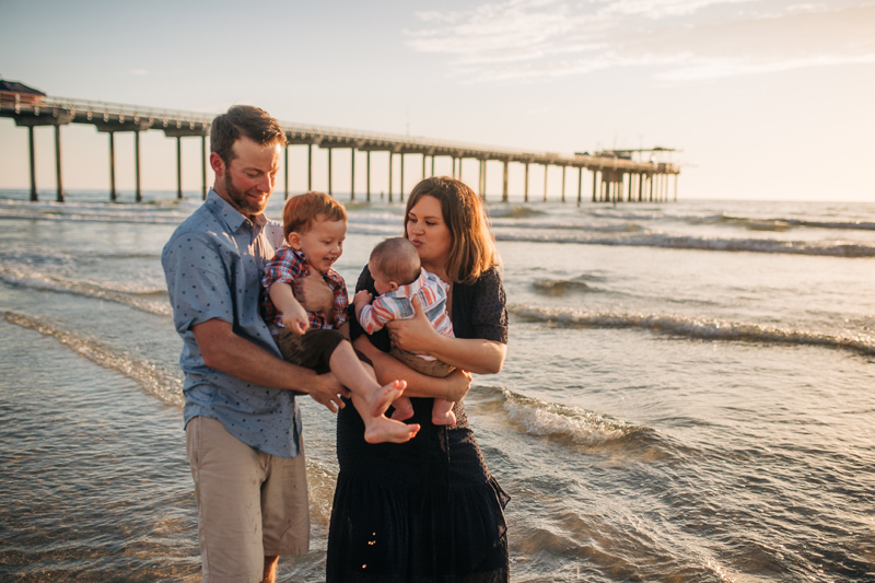 Temecula Family Photographer, family of four standing next to the ocean